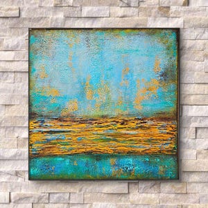 Può includere: Dipinto astratto quadrato con superficie strutturata. L'opera presenta una miscela di tonalità turchese, oro e marrone. La parte superiore è principalmente turchese con accenti dorati, mentre la sezione inferiore mostra una fascia dorata e marrone.