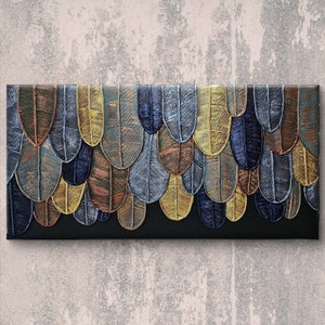 Può includere: Opera d'arte astratta strutturata con un motivo di forme sovrapposte a forma di scudo. Le forme sono in tonalità di marrone, oro, blu e grigio, con uno sfondo nero. L'opera è montata su una tela rettangolare.