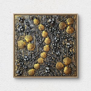 Può includere: Opera d'arte da parete quadrata con sfondo nero e oro strutturato, adornata con conchiglie dorate e accenti floreali grigio scuro. L'opera è incorniciata in legno naturale.