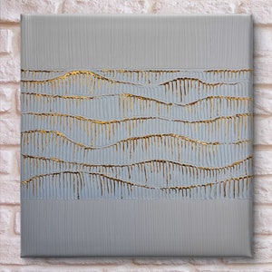 Può includere: Dipinto astratto su tela con sfondo grigio e linee dorate che creano un motivo ondulato.