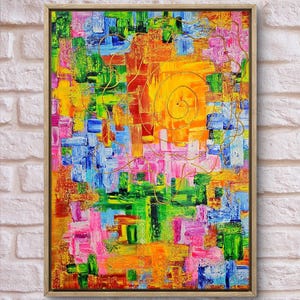 Può includere: Dipinto astratto in una cornice di legno. L'opera presenta un vivace mix di colori, tra cui giallo, arancione, verde, blu e rosa, applicati con pennellate visibili. Una spirale e linee dorate sovrappongono lo sfondo colorato.