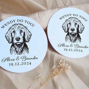 Op de afbeelding: Twee ronde witte onderzetters met zwarte hondenillustraties en de tekst "WENDY DO TOO!" Alexa & Branden 19.12.2024.