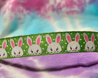 May include: Green dog collar with white bunnies and pink ears on a green polka dot background. The collar has a silver buckle and a silver D-ring.