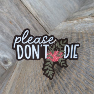 May include: Black and white sticker with the text "please don't die" and a hanging plant with a red and white patterned pot.