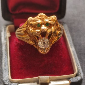 A chunky Antique 14ct gold lions head ring with an oldcut diamond & emeralds