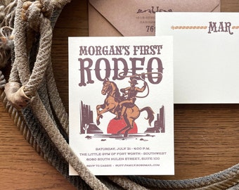 Może przedstawiać: Beżowa i brązowa karta zaproszenia z kowbojem jadącym na koniu, który się wygina. Tekst brzmi "Morgan's First Rodeo" i zawiera datę, godzinę i miejsce wydarzenia. Zawiera również informacje RSVP.