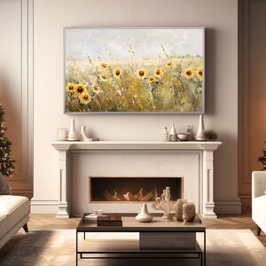 May include: A painting of a field of sunflowers in a light blue, yellow, and green color scheme. The sunflowers are in various stages of bloom, with some fully open and others still in bud. The painting is framed in a silver frame and is hanging above a fireplace.