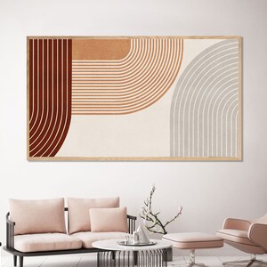 May include: Abstract art print with a geometric design featuring curved lines in shades of brown, orange, and gray. The print is framed in a natural wood frame.