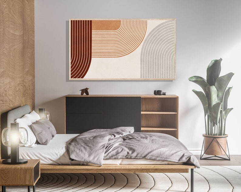 May include: A bedroom interior with a modern bed, a wooden nightstand, and a black and wood cabinet with shelves. A large abstract print with red, orange, and gray geometric shapes hangs on the wall above the cabinet. A potted plant with green leaves sits on the floor next to the cabinet.