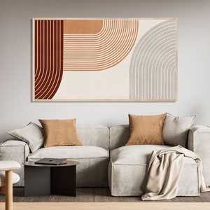 May include: Abstract art print with a geometric design featuring curved lines in shades of brown, orange, and gray. The print is framed and hanging on a wall above a white sofa.