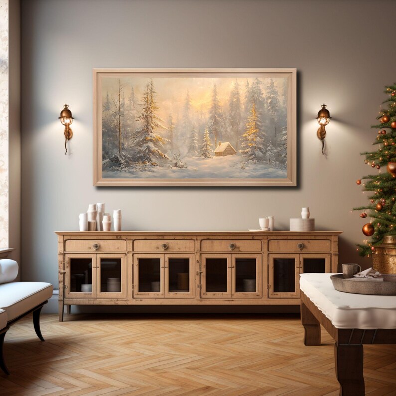 May include: A framed painting of a snowy forest scene with a small cabin in the distance. The painting is hanging on a wall above a wooden cabinet with glass doors. The cabinet is in a room with a wooden floor and a Christmas tree in the background.