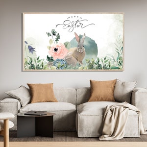 May include: A watercolor painting of a bunny rabbit in a field of flowers. The text "Happy Easter" is written in cursive above the bunny. The painting is framed in a light wood frame.