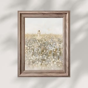 Könnte beinhalten: Ein gerahmter Kunstdruck mit einer ruhigen Landschaft. Das Kunstwerk zeigt eine Person, die in einem Feld weißer Blumen steht. Der Rahmen ist hellbraun und verleiht dem Stück einen rustikalen Touch. Die Farbpalette ist weich und gedämpft.