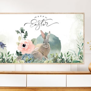 May include: A watercolor painting of two rabbits in a floral setting. The rabbits are brown and gray with long ears. The flowers are pink, blue, and green. The text "Happy Easter" is written in cursive at the top of the painting.