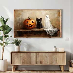 Pode incluir: Um gato preto com um fantasma branco e uma ab&oacute;bora talhada com uma cara de ab&oacute;bora em uma mesa de madeira. O gato est&aacute; olhando para o espectador. O fantasma est&aacute; flutuando sobre a mesa. A ab&oacute;bora est&aacute; talhada com uma cara de ab&oacute;bora.