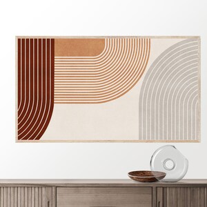 May include: Abstract art print with a geometric design featuring curved lines in shades of brown, orange, and gray. The print is framed in a light wood frame.