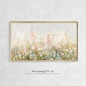 Könnte beinhalten: Ein gerahmtes Gemälde, das ein Feld mit Wildblumen in Rosa-, Weiß- und Blautönen zeigt. Die Blumen sind in einem weichen, impressionistischen Stil gemalt, und der Hintergrund ist ein nebliges Blau.