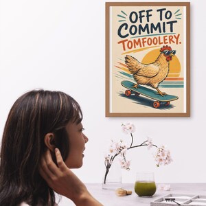 May include: A framed wall art print featuring a light brown chicken wearing sunglasses while riding a skateboard. The text reads OFF TO COMMIT TOMFOOLERY. The background includes a stylized orange sun and horizontal motion lines in blue and orange.