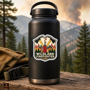 May include: Black insulated water bottle with a sticker featuring crossed axes, a red fire extinguisher, and the text "Wildland Firefighter." The sticker is set against a backdrop of a forest and mountains.
