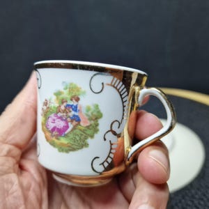 Vintage Courting Couple Demitasse Cup & Saucer - Gold Trim Porcelain. This exquisite vintage demitasse cup and saucer set features a ...