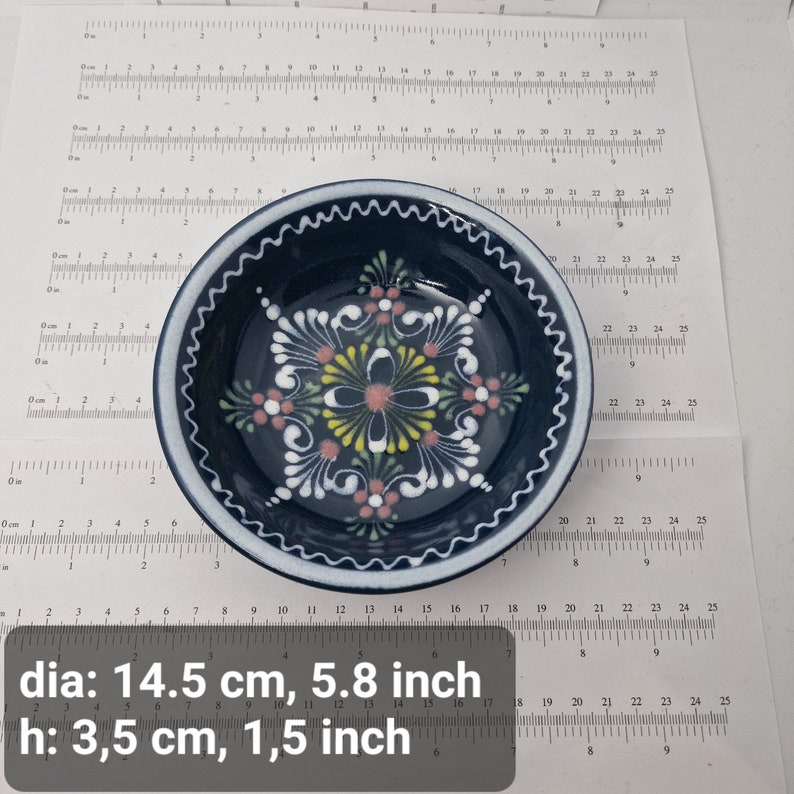 K&ouml;nnte beinhalten: Eine kleine, blaue Keramikschale mit wei&szlig;em Rand und einem floralen Design in Rosa, Gelb und Wei&szlig;. Die Schale misst 14,5 cm im Durchmesser und 3,5 cm in der H&ouml;he.