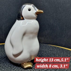 Elegant Ceramic Penguin Figurine with Gold Accents. This charming ceramic penguin figurine features a glossy ...