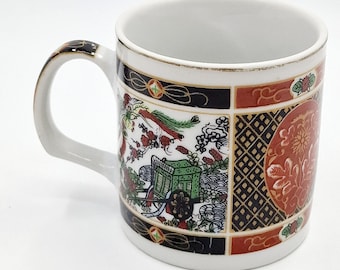 May include: White ceramic mug with a gold rim and a colourful Japanese-inspired design featuring a cart, flowers, and geometric patterns.