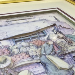 Könnte beinhalten: Ein gerahmtes, dreidimensionales Kunstwerk, das eine Marktszene darstellt. Das Kunstwerk zeigt einen Verkäufer, Kunden und verschiedene Produkte. Die Farbpalette umfasst sanfte Blau-, Rosa- und Grüntöne und erzeugt eine Vintage-Ästhetik. Der Rahmen ist goldfarben.