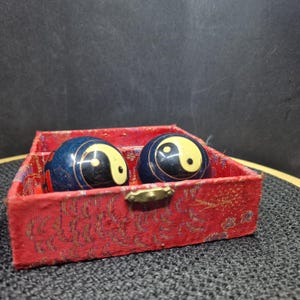 Vintage Chinese Baoding Balls - Yin Yang Design, Blue & Red, with Box. Discover this captivating pair of vintage Chinese Baoding balls,