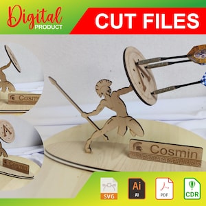 May include: A wooden cutout of a warrior holding a shield and spear, with three darts stuck in the shield. The warrior is standing on a wooden base with the name "Cosmin" engraved on it. The image is labeled "Digital Product" and "Cut Files".