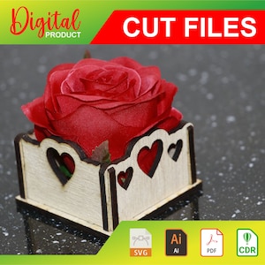 Peut inclure: Une rose rouge dans une boîte en bois avec des découpes en forme de cœur. La boîte est en bois clair avec des bords marron foncé. L'image comprend également le texte "CUT FILES" et "Digital PRODUCT".