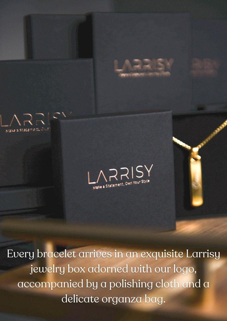 Może przedstawiać: Czarne pudełko na biżuterię z napisem "LARRISY Make a Statement. Own Your Style." w złotych literach. Pudełko jest otwarte, a wewnątrz widać złoty naszyjnik z zawieszką.