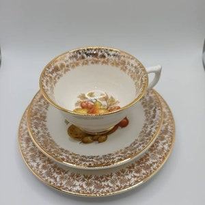 Vintage Worcester Trio .Cup saucer and tea plate with a lovely fruit decoration with a  gold pattern and guilded rims C1970s Super condition