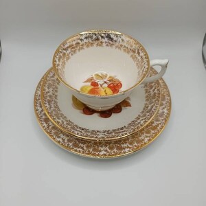 Vintage Worcester Trio. Cup saucer and tea plate with a lovely fruit decoration with a gold pattern and guilded rims C1970s Super condition