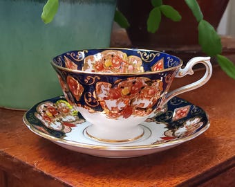 May include: A blue and gold teacup and saucer set with a floral pattern. The cup and saucer are decorated with intricate details and a gold trim.