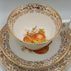 Vintage Worcester Trio. Cup saucer and tea plate with a lovely fruit decoration with a gold pattern and guilded rims C1970s Super condition