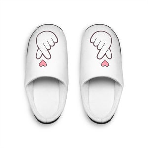 May include: A pair of white slippers with a pink heart and a hand gesture on each slipper.