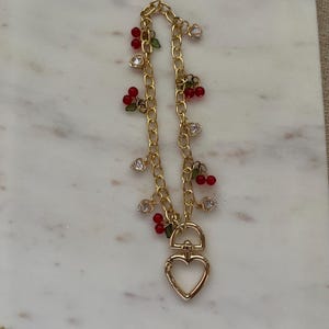 Pulsera para teléfono con cadena dorada de cereza y corazón: un accesorio elegante y divertido