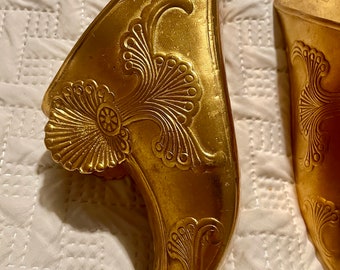 Par de zapatos pesados de latón dorado ornamentados, propios de un conquistador del siglo XIX, de la época de la conquista.