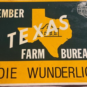 May include: Vintage metal sign with a green background and yellow border. The sign features the words "MEMBER TEXAS FARM BUREAU" in white, with the outline of Texas in yellow. The name "ELDIE WUNDERLICH" is printed at the bottom.