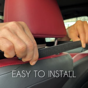 Peut inclure: Installation d'une sangle noire sur un si&egrave;ge de voiture noir et rouge. Le texte blanc indique "EASY TO INSTALL".