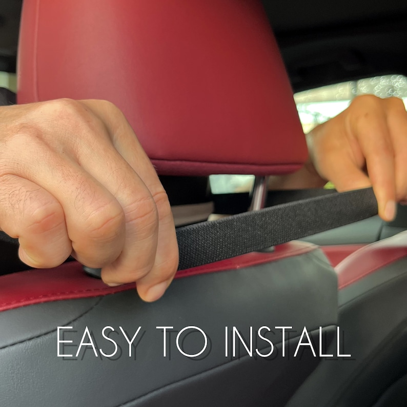 Peut inclure: Installation d'une sangle noire sur un si&egrave;ge de voiture noir et rouge. Le texte blanc indique "EASY TO INSTALL".