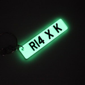 May include: A glow-in-the-dark keychain with a black license plate design that says "R14 XK".