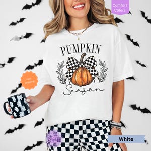 May include: White t-shirt with a black and white checkered bow on a pumpkin with the text "Pumpkin Season".