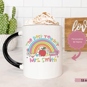 May include: White ceramic mug with a black handle. The mug has a rainbow, apple, pencil, and the text "The Best Teacher Mrs. Smith" printed on it. The mug is 11 ounces.