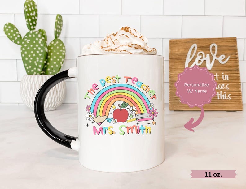 May include: White ceramic mug with a black handle. The mug has a rainbow, apple, pencil, and the text "The Best Teacher Mrs. Smith" printed on it. The mug is 11 ounces.