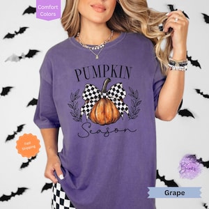 May include: Purple t-shirt with a black and white checkered bow on a pumpkin with the text "Pumpkin Season".