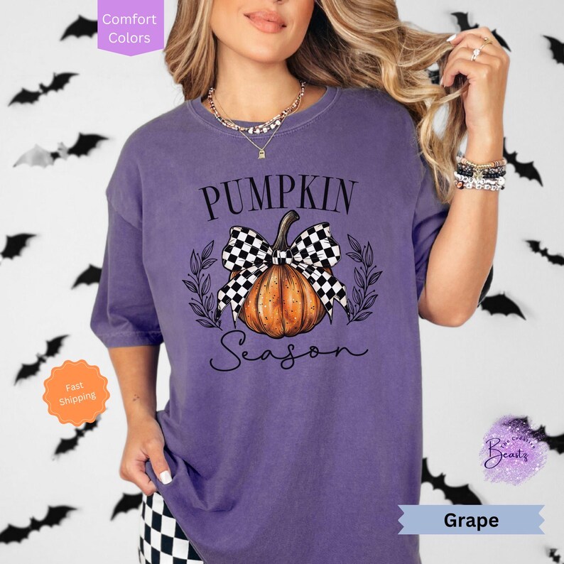 May include: Purple t-shirt with a black and white checkered bow on a pumpkin with the text "Pumpkin Season".