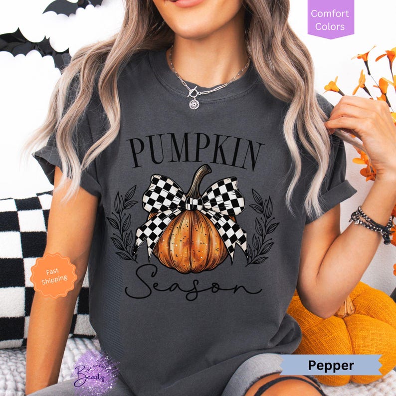 May include: A gray t-shirt with a black and white checkered bow on a pumpkin with the text "Pumpkin Season".