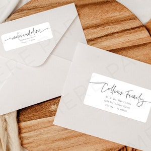 Könnte beinhalten: Zwei weiße Umschläge mit handgeschriebenen Adressaufklebern. Das obere Etikett lautet "Rachel und Alan" und das untere Etikett lautet "Collins Family" mit einer Adresse.